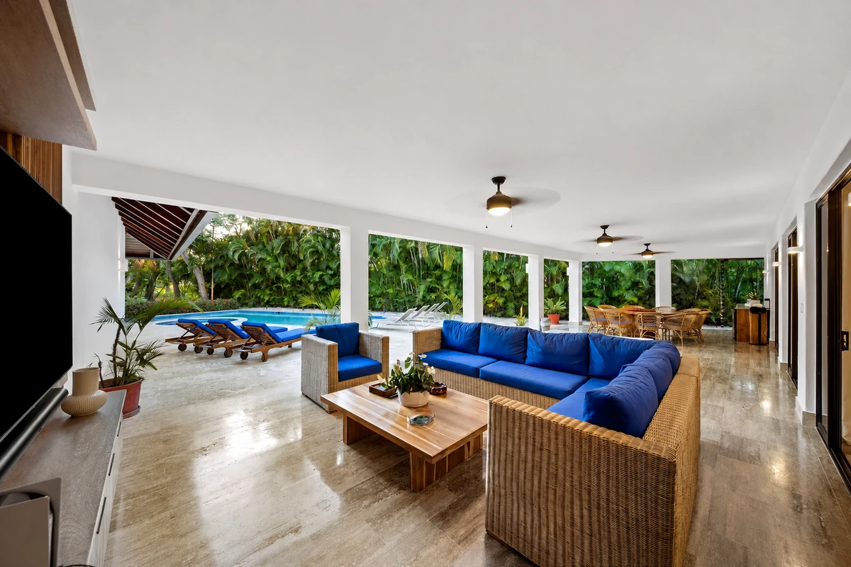 Long covered terrace with lounge, outdoor dining and direct access to the pool