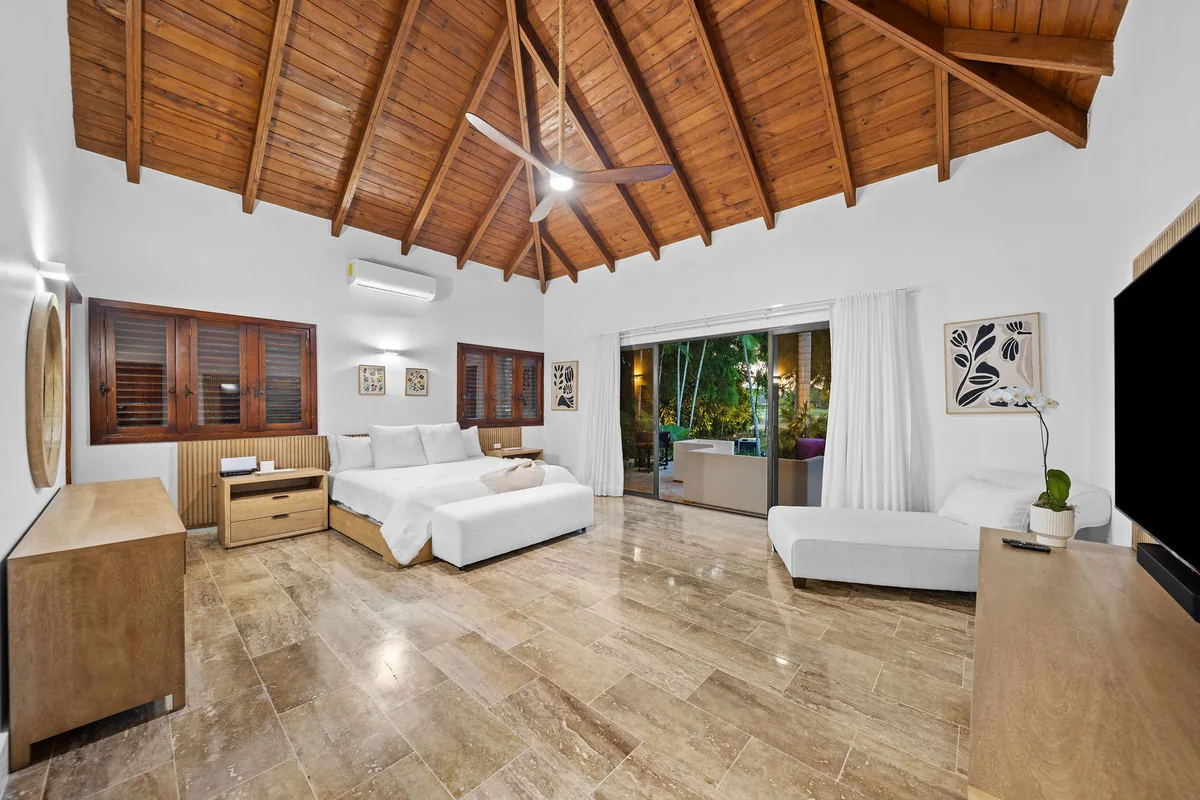 Primary bedroom with king bed, timber ceiling and garden access