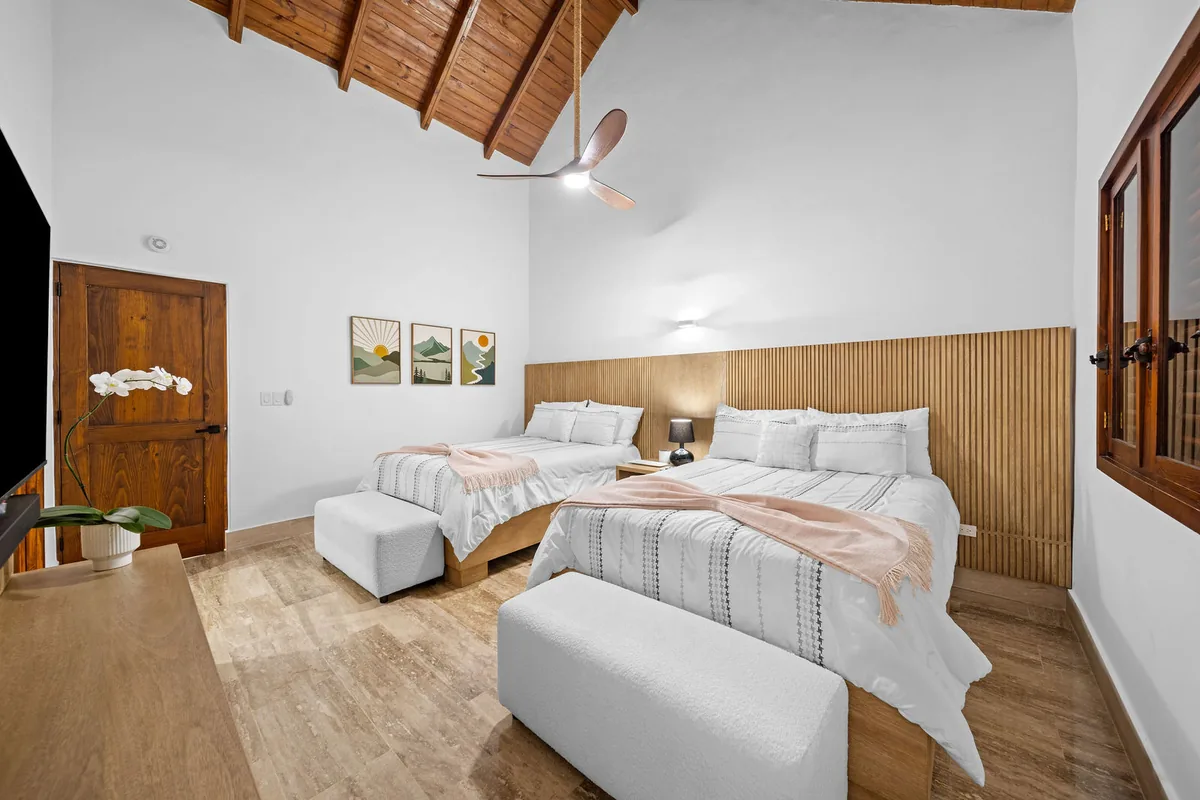Guest bedroom with two queen beds and vaulted timber ceiling
